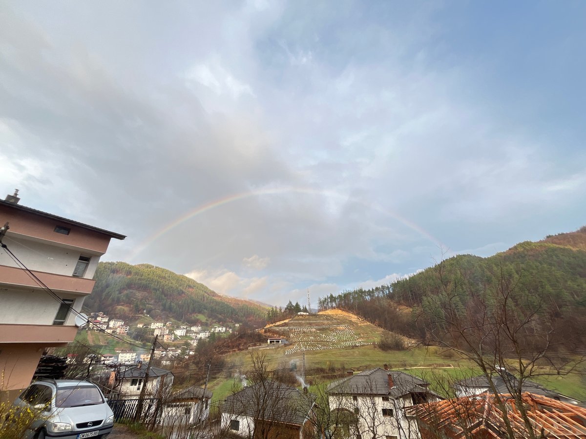 Rainbow appears over Chepintsi, Bulgaria hillside residential area