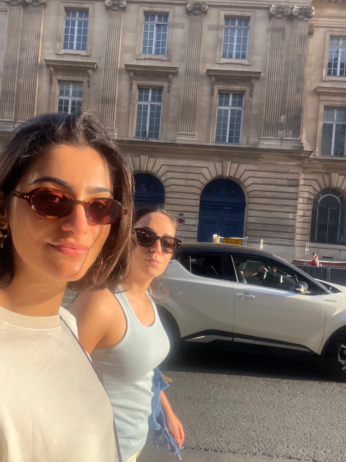 Two women pose for photos on Paris street