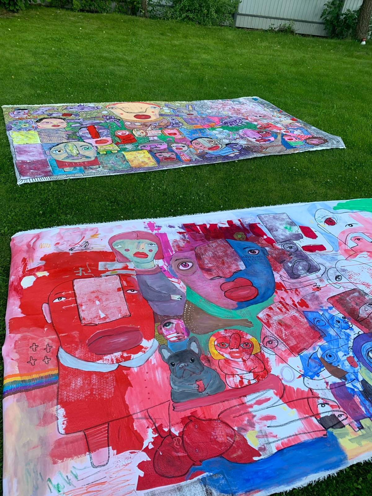 Folk art face sculptures displayed on a lawn in Sergeevo