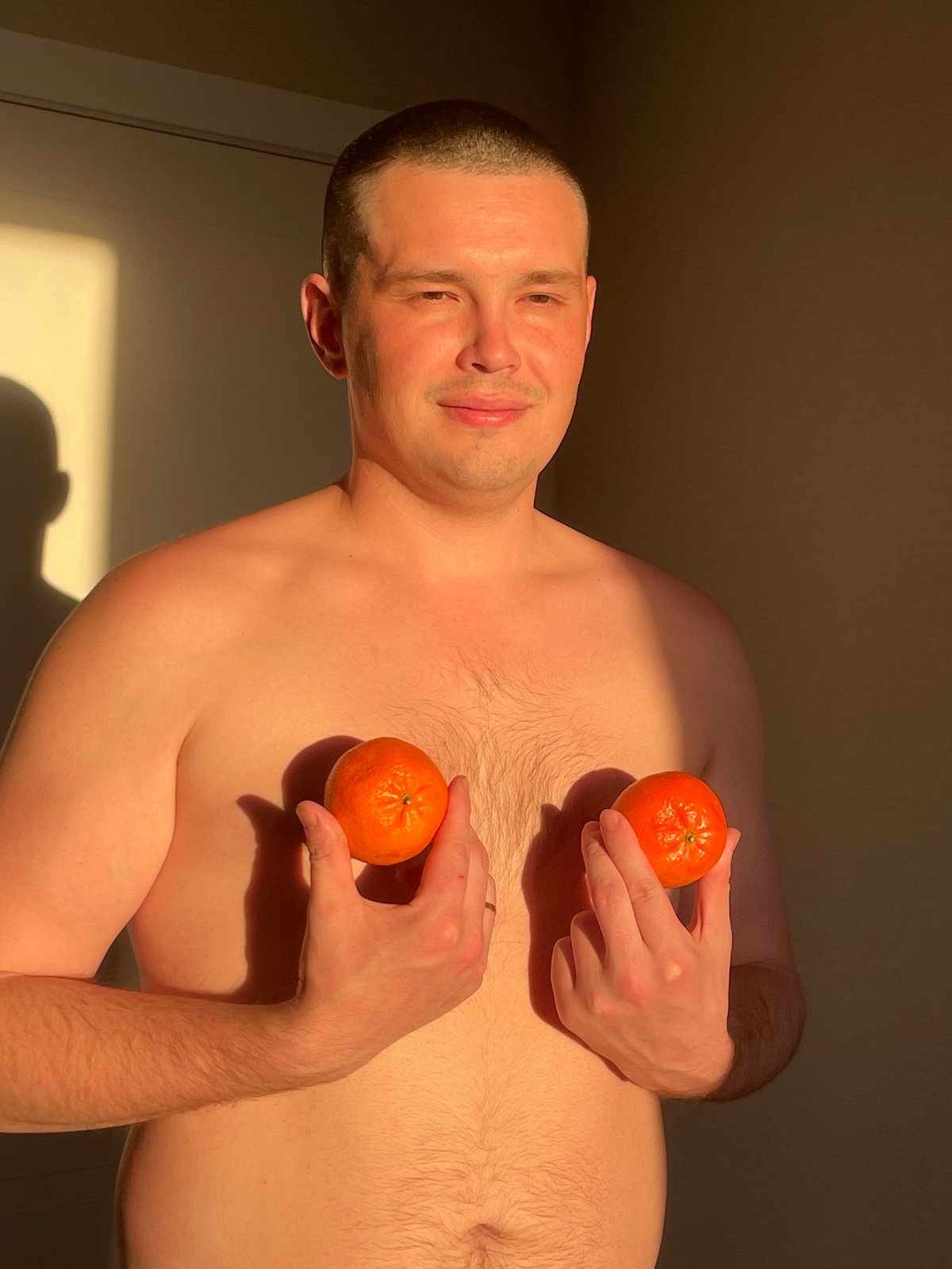 Man holds tangerines in Russian village, tagged #Fruit