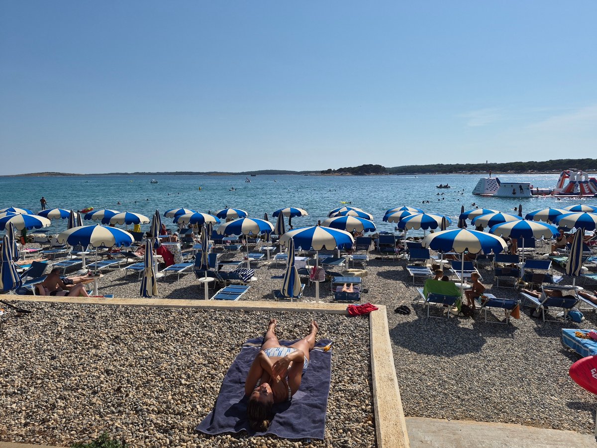 Sunny afternoon at a busy Croatian pebble beach