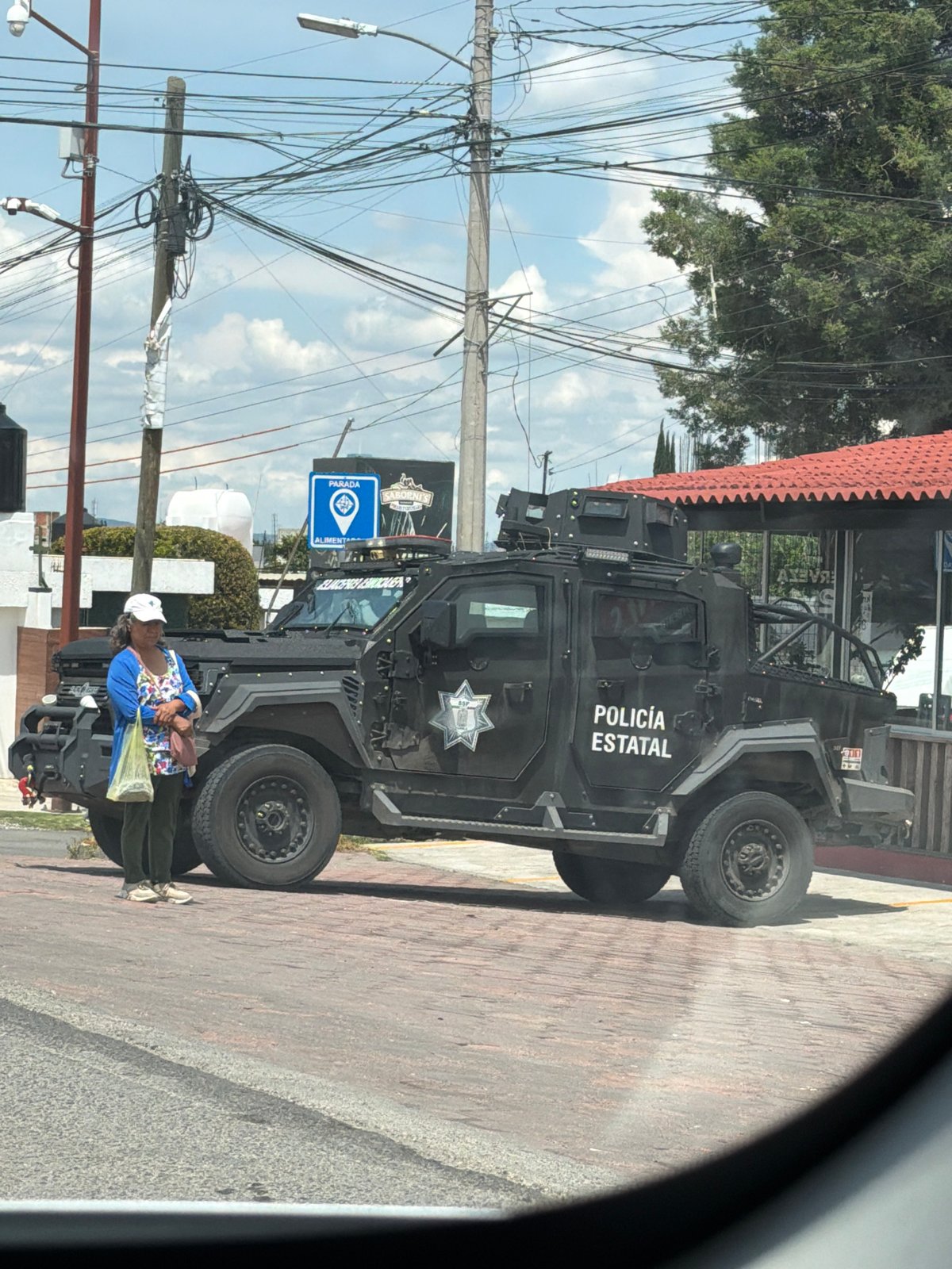Armored state police vehicle on a brick sidewalk in Puebla