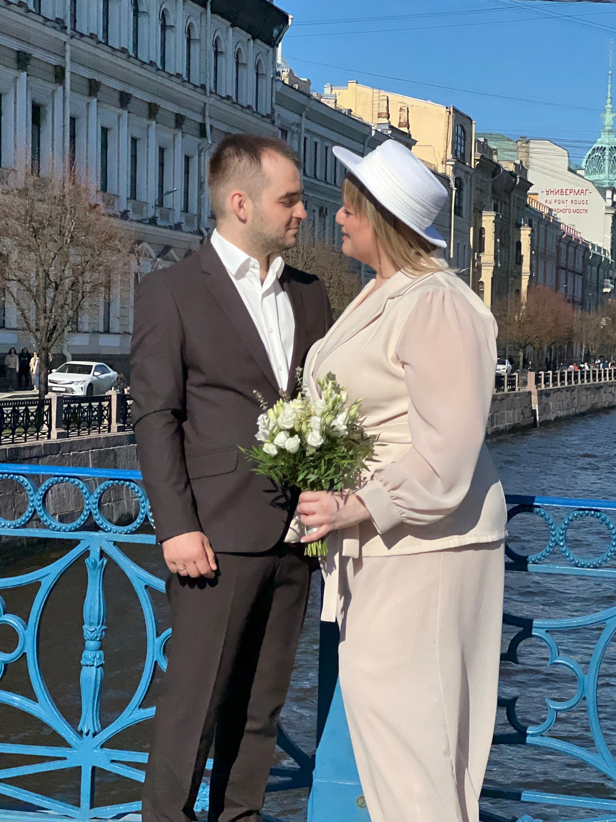 Newlyweds pose on Saint Petersburg bridge as boats pass below