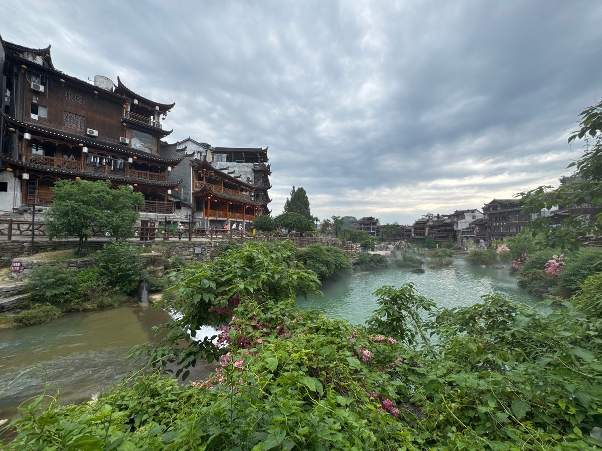 Morning mist rises over Furong Ancient Town river