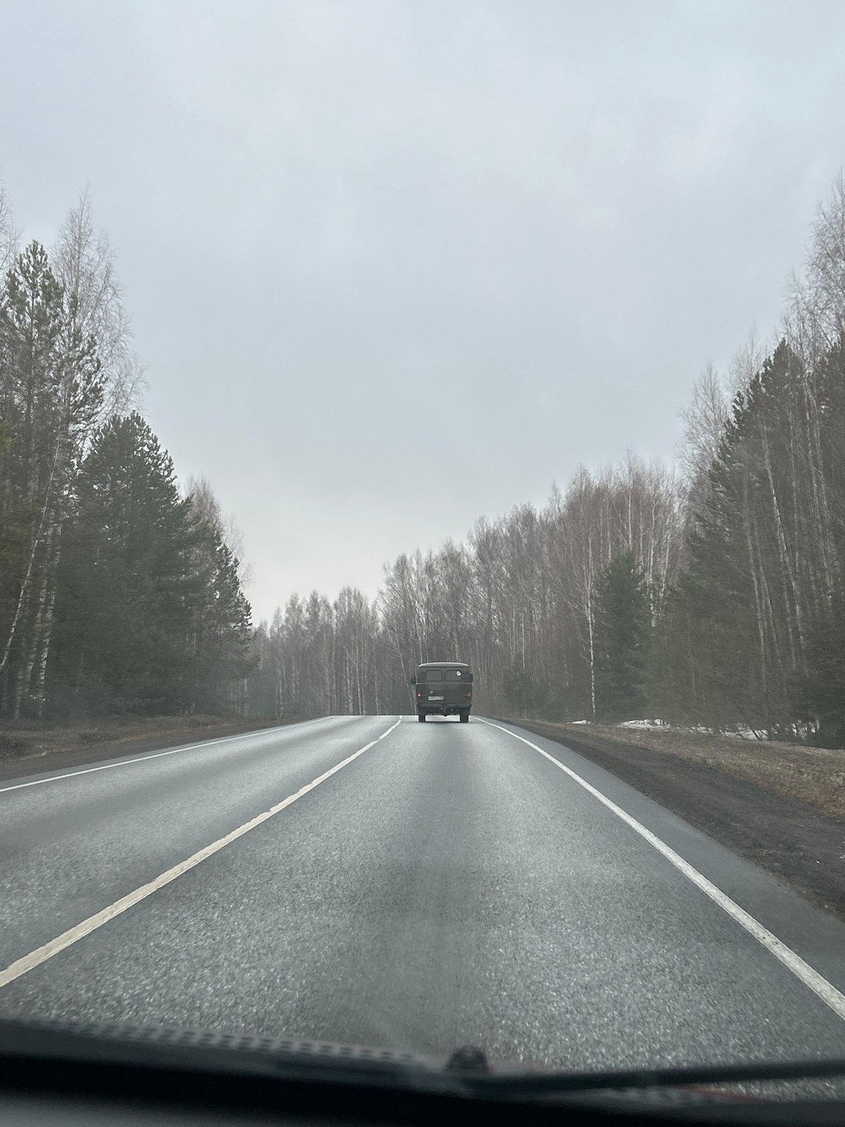 Vehicle travels wet road in Oralki, Russia