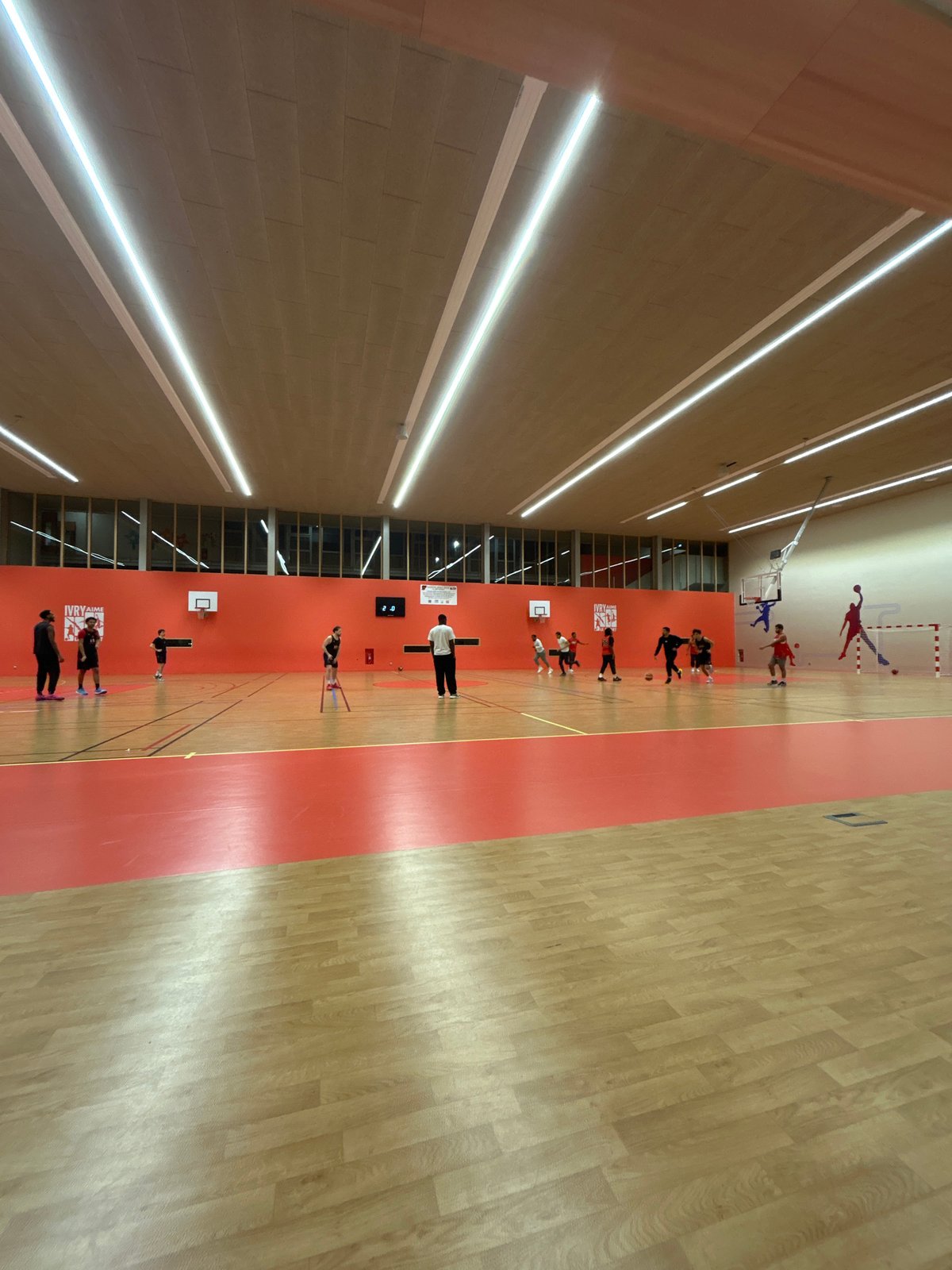 Evening handball training session documented in Ivry-sur-Seine gymnasium