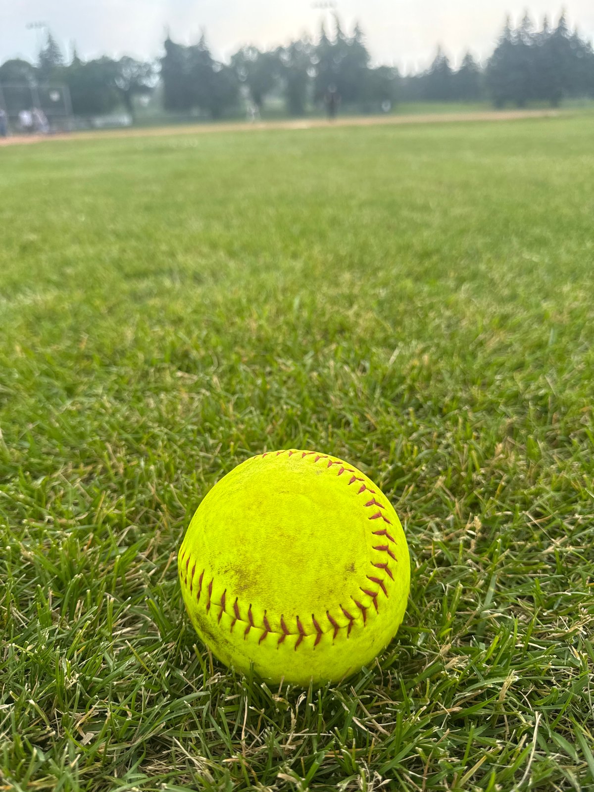 Casual softball game on a cloudy Canada Day evening
