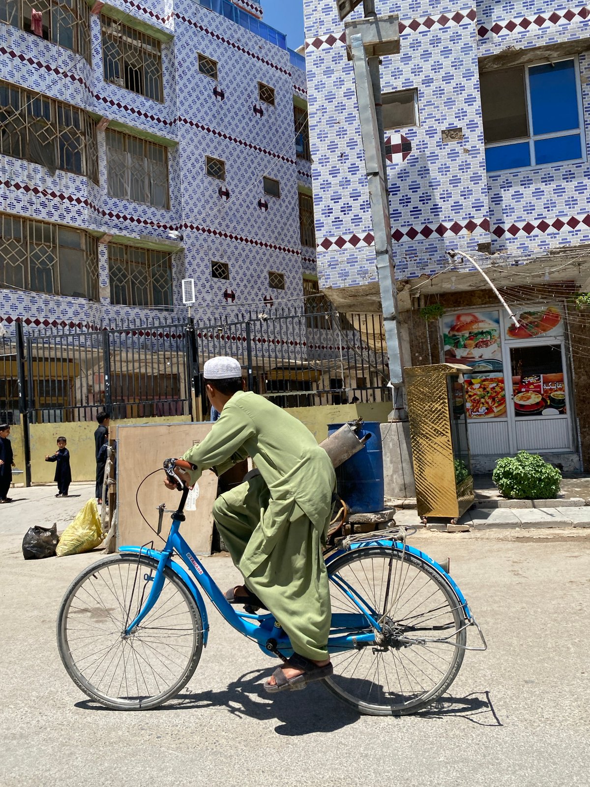 Street life in Kandahar: cycling and a roadside food stall