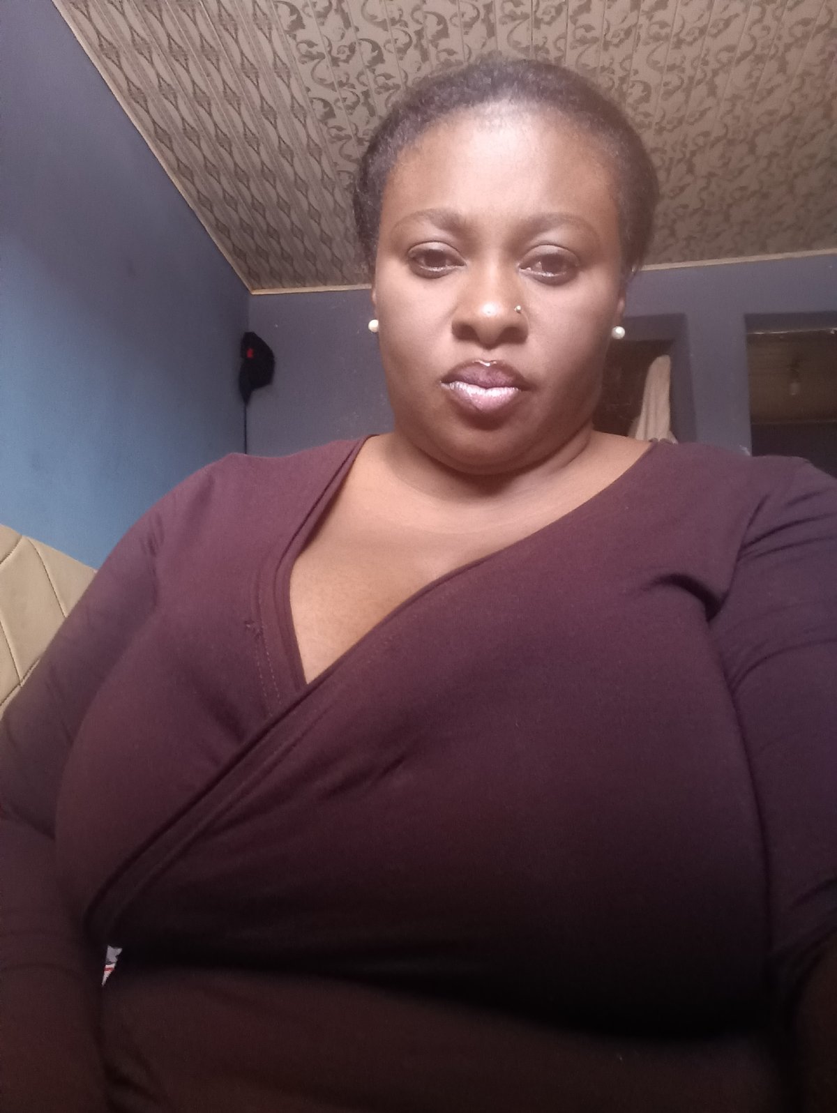 Woman in maroon attire observed indoors in Jos, Nigeria