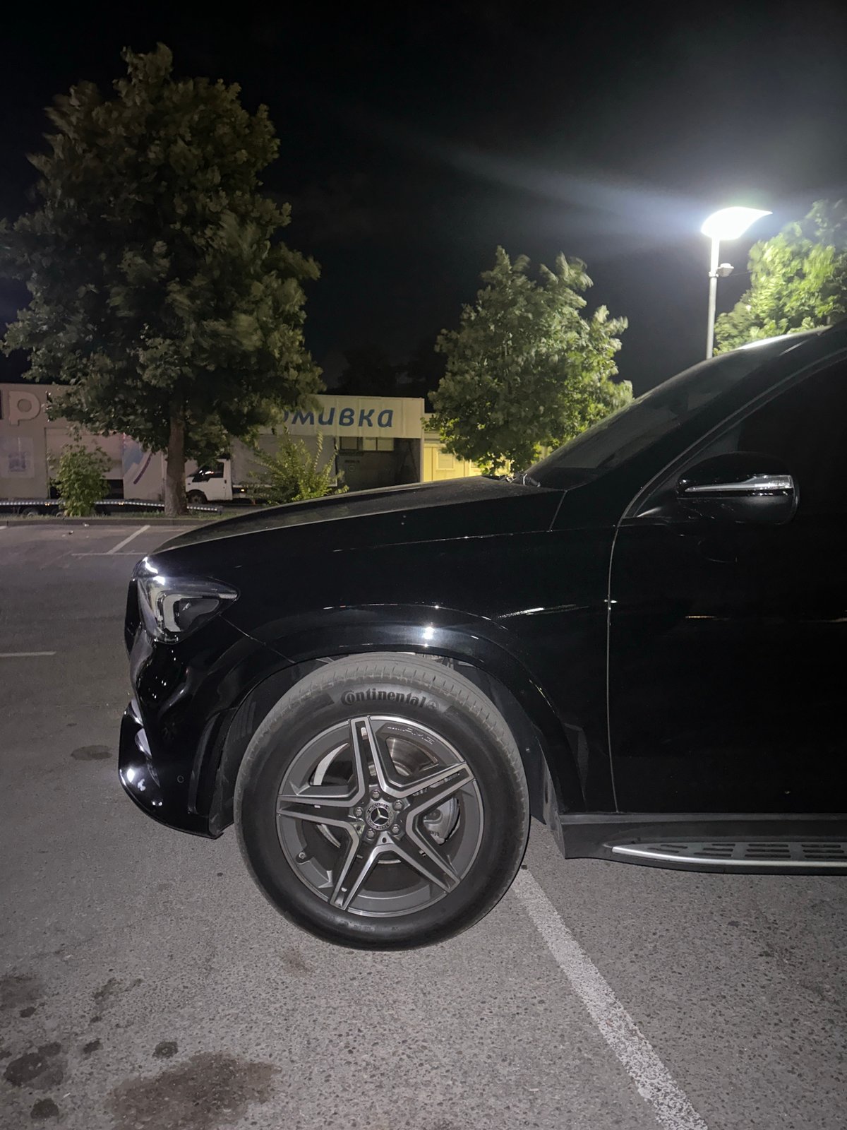 Black Mercedes GLE parked outside a Ruse car wash at night
