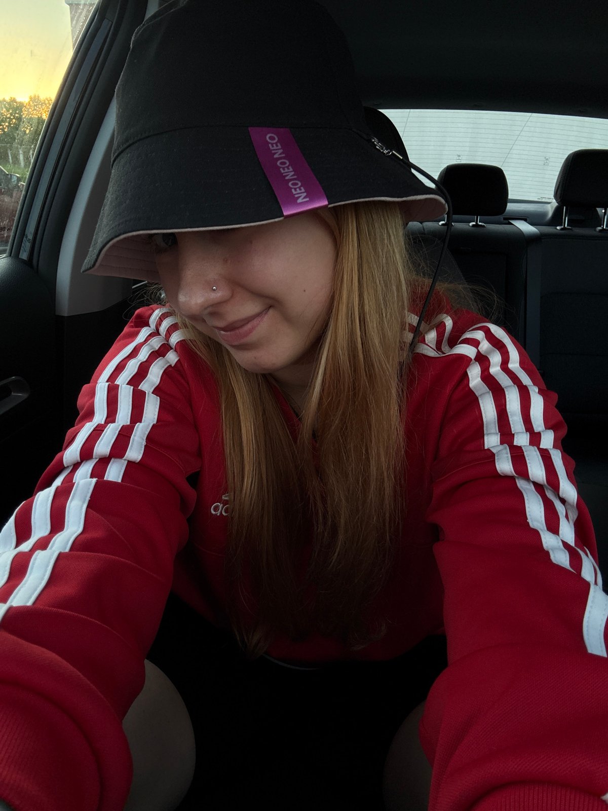 Person in tracksuit smokes cigar in Minsk parking lot