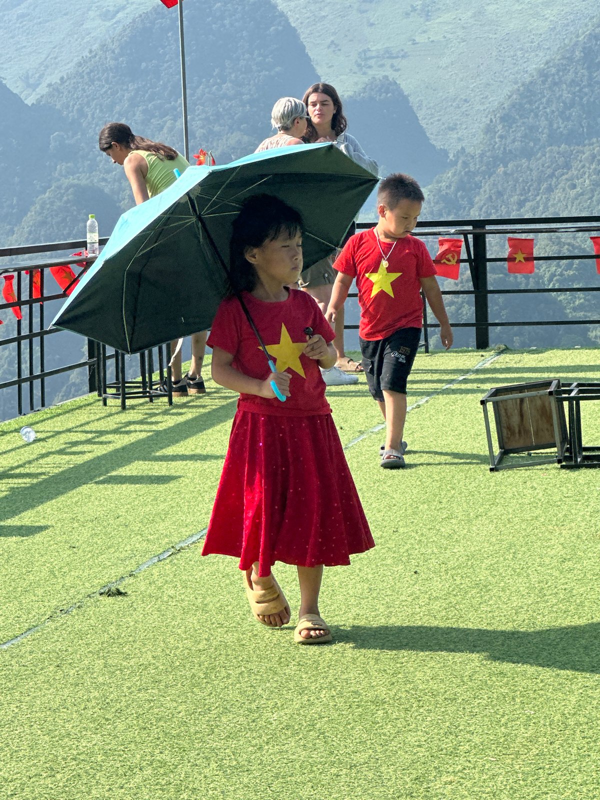 Families gather at Vietnamese mountain viewing platform during morning visit