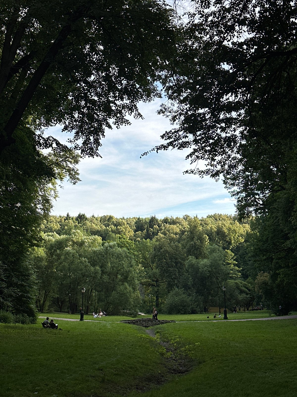 Afternoon in a Moscow park, lawns and a marble statue