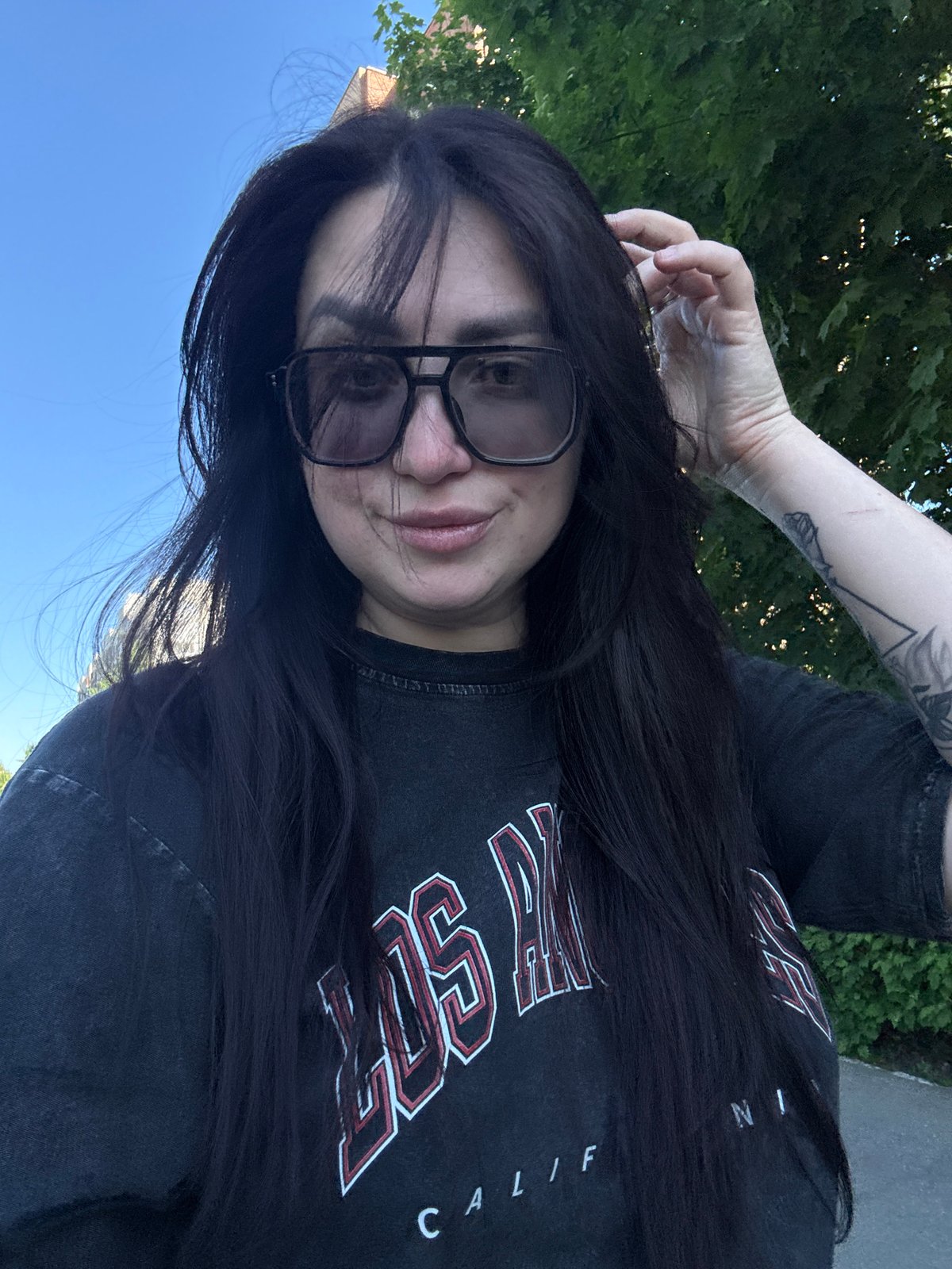 Woman in glasses photographed outdoors in dark t-shirt