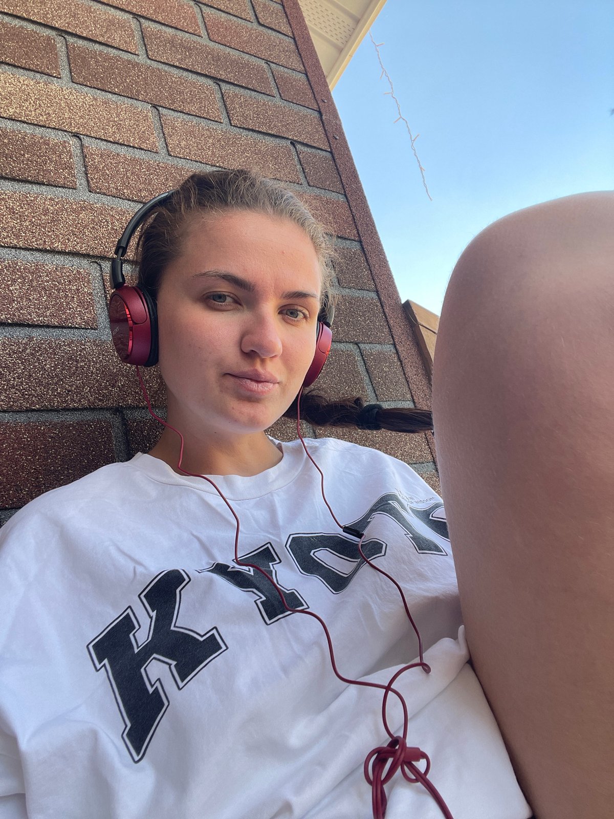 Woman relaxes with headphones on Moscow-area rooftops and decking