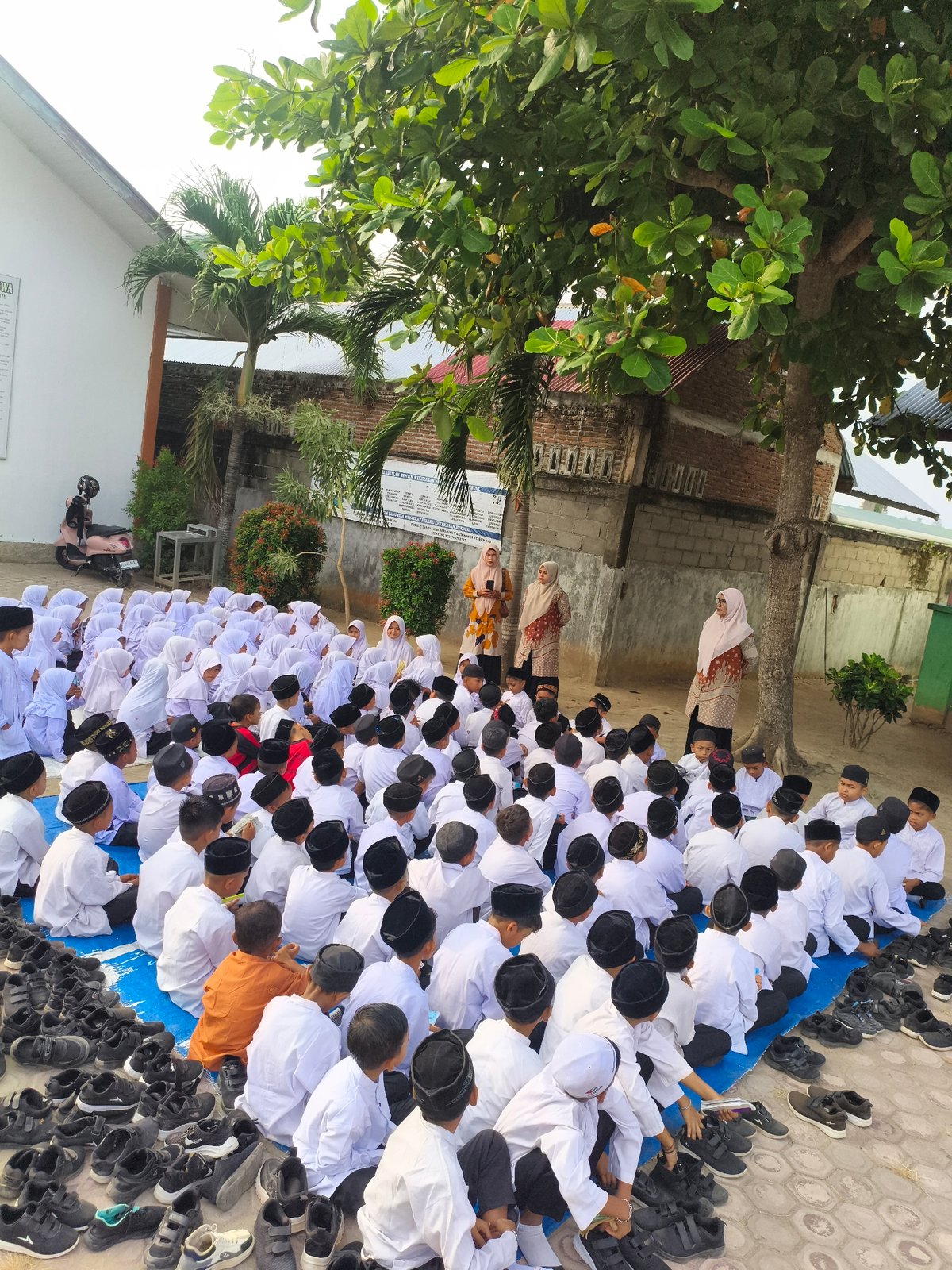 Children in Islamic dress gather for outdoor religious session in Indonesia