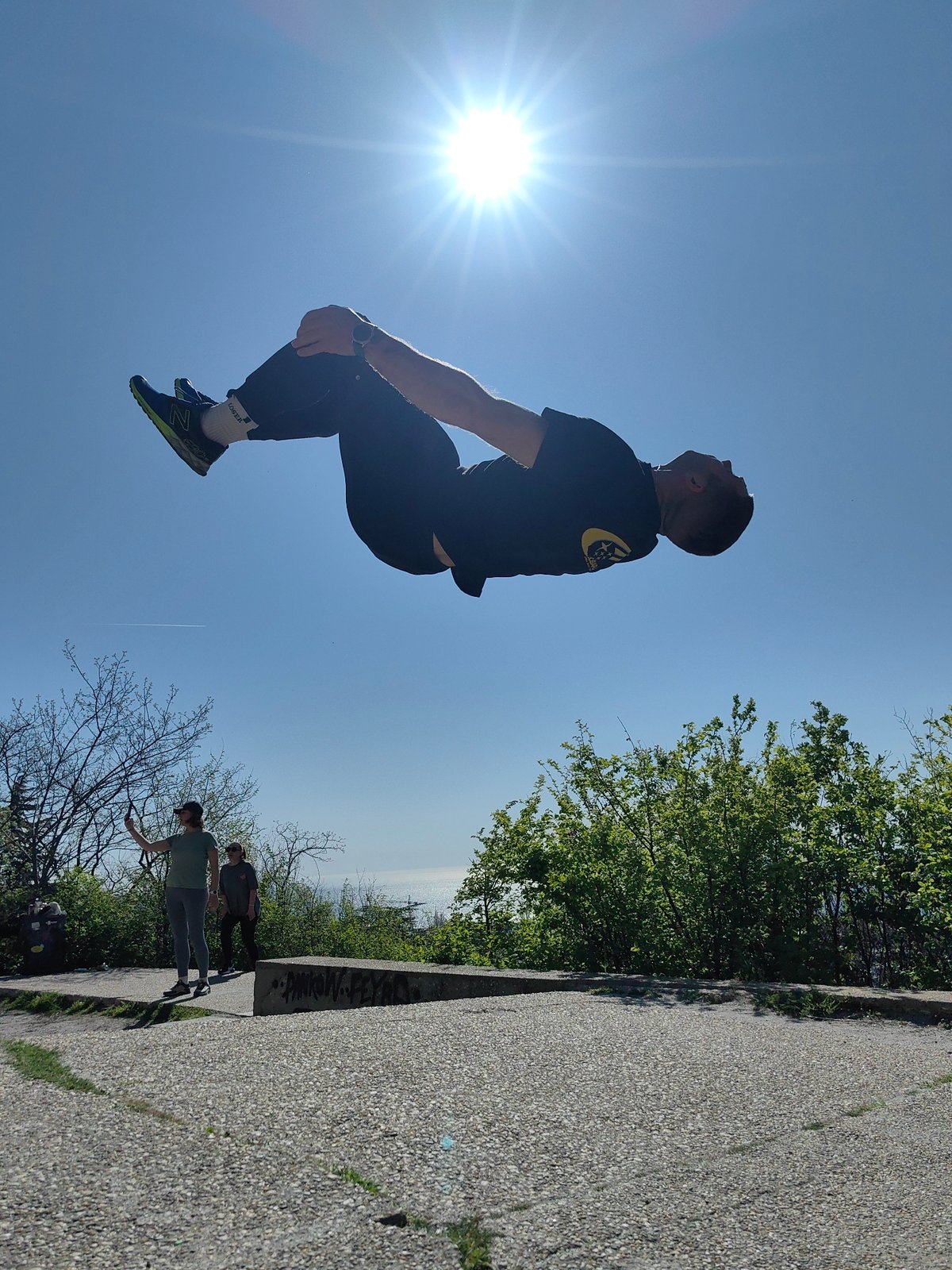 Man performs backflips and aerial stunts in urban park