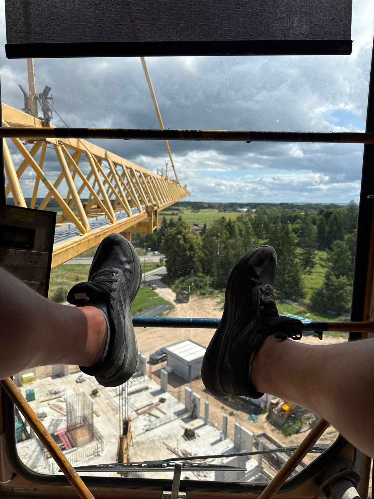 Crane work underway in Mikołajki, Poland, overlooking lake and fields