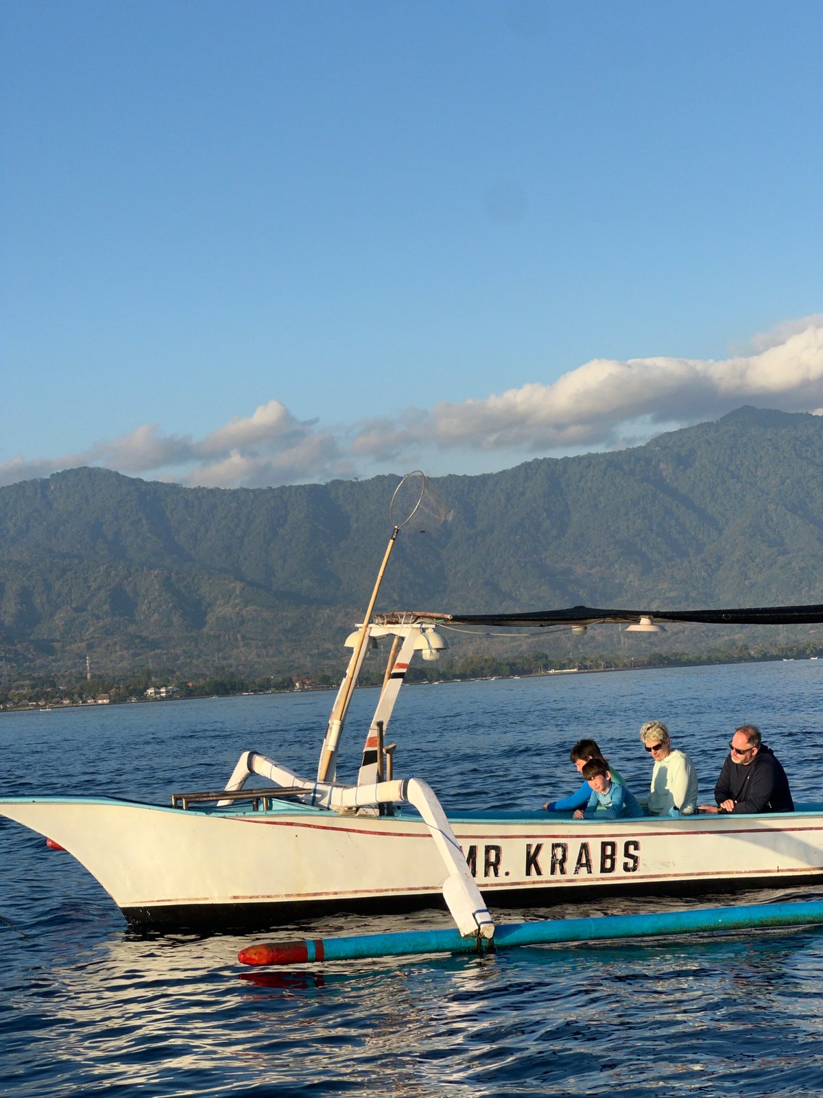 Traditional boats on calm Indonesian waters at sunset