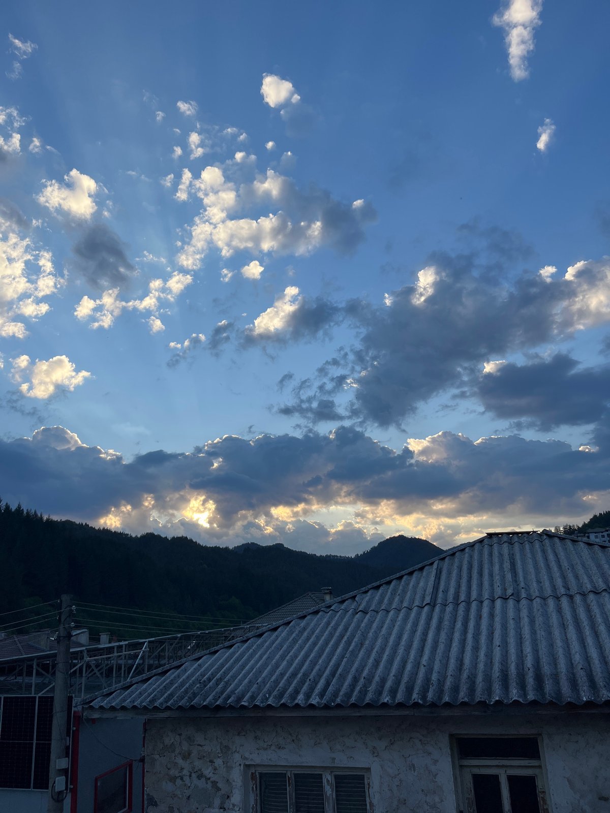 Man relaxes on balcony overlooking Bulgarian mountain town