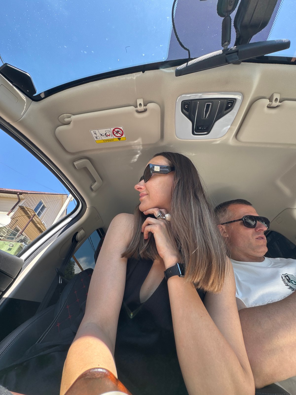 Woman takes selfies in car during sunny day in Sochi