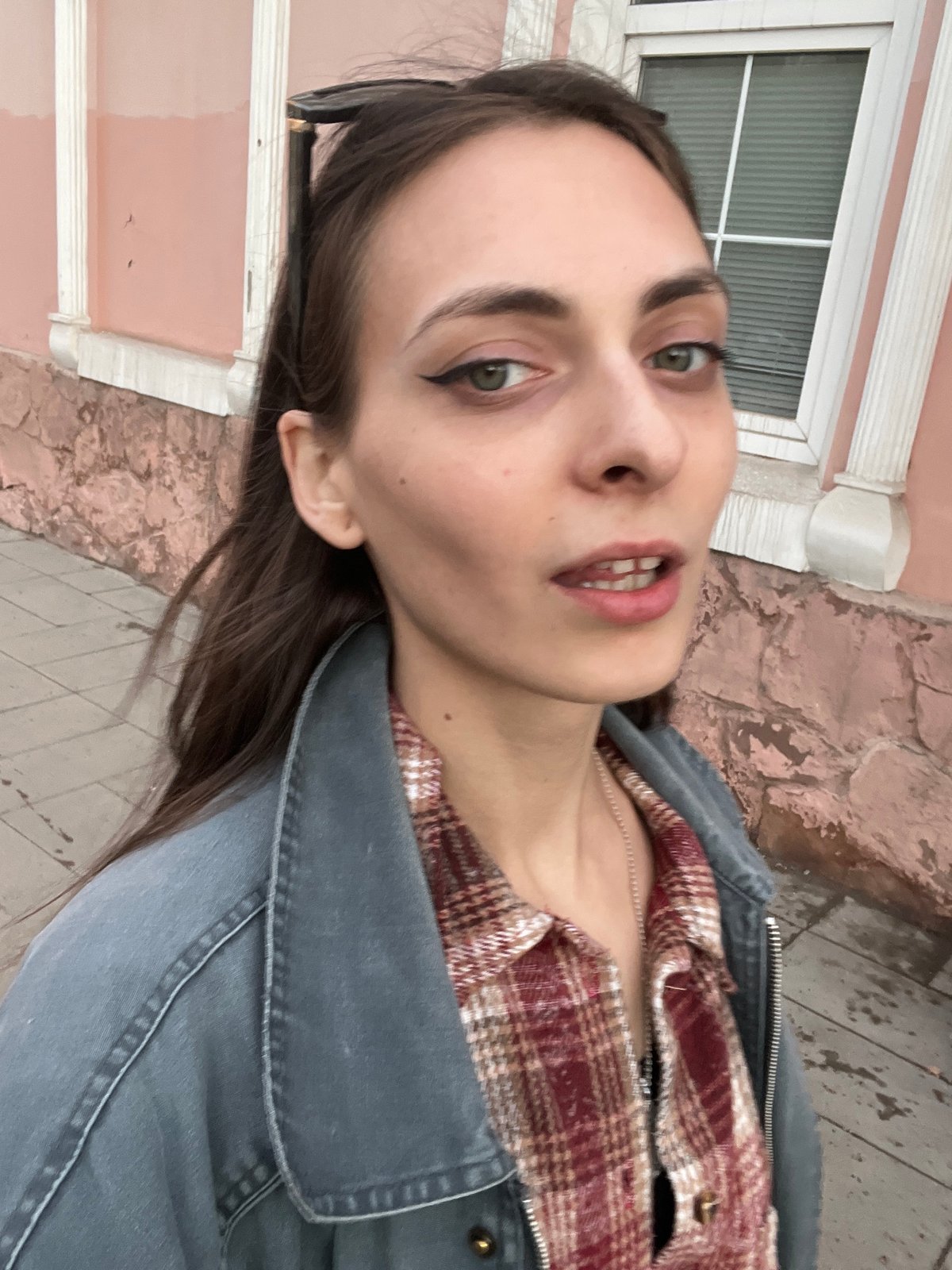 Woman takes selfie near pink building in Krasnoyarsk