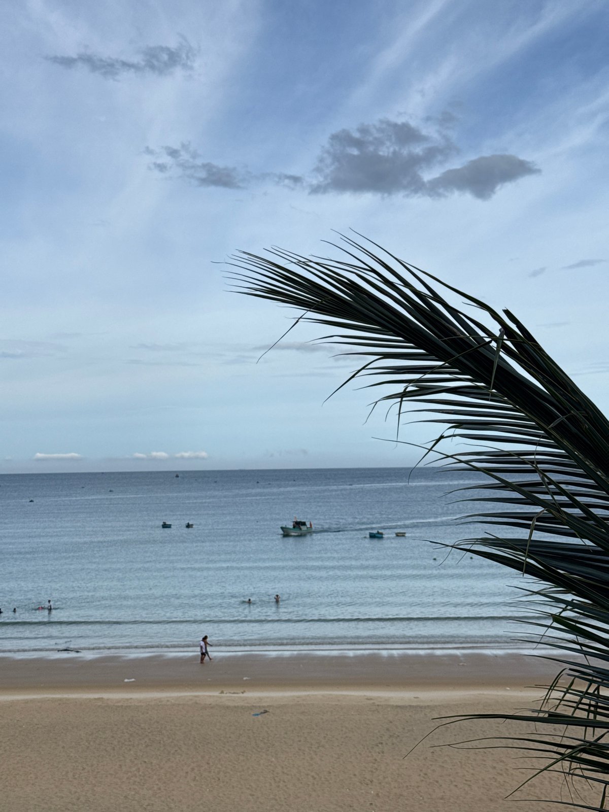 Quiet beach morning, calm surf, people strolling the shoreline