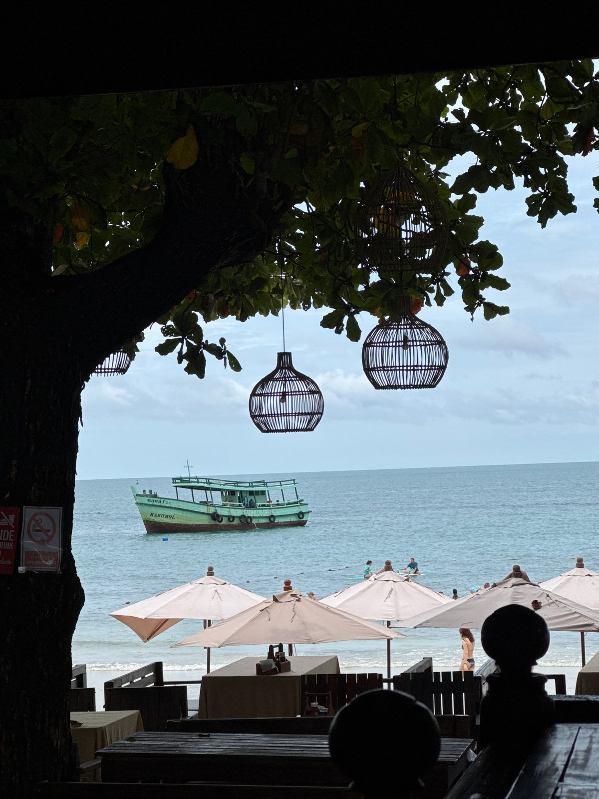Shaded beachfront restaurant overlooks calm ocean at Ao Phai