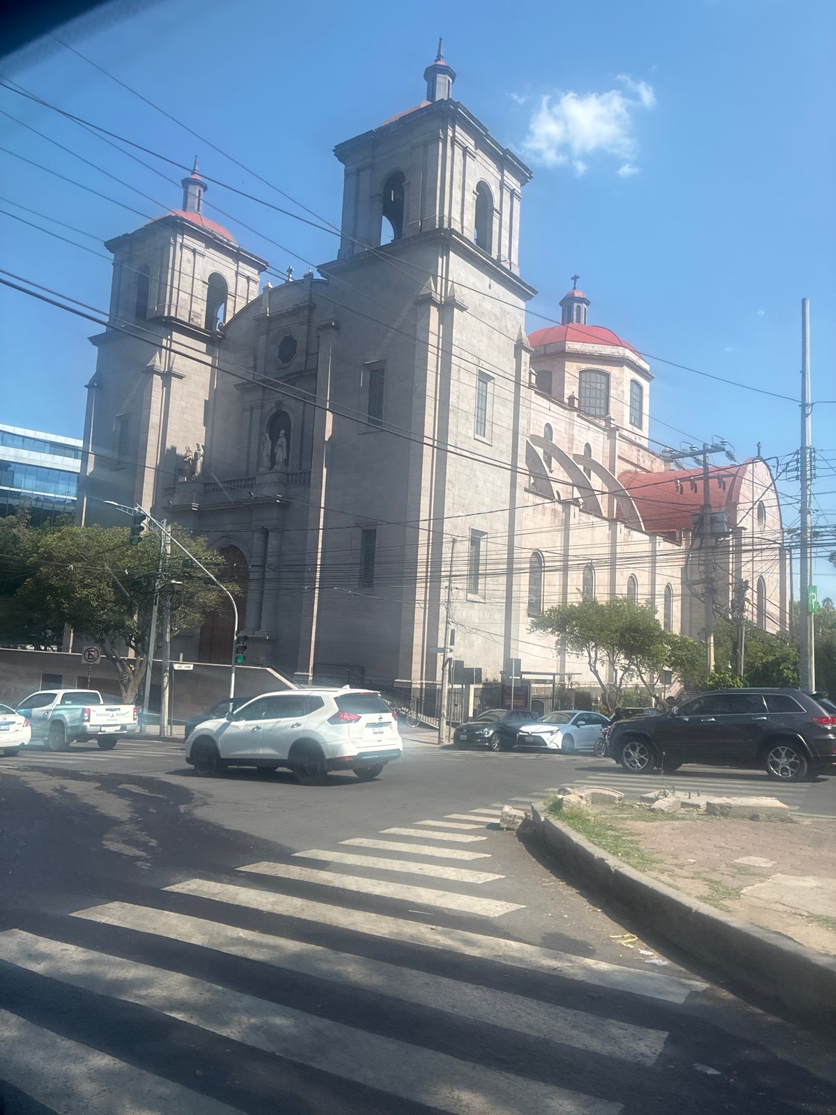 Mexico City cathedral with red domes captured in evening street scene