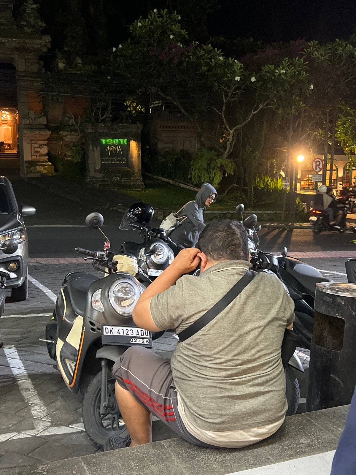 Motor scooter parked on Ubud street at night