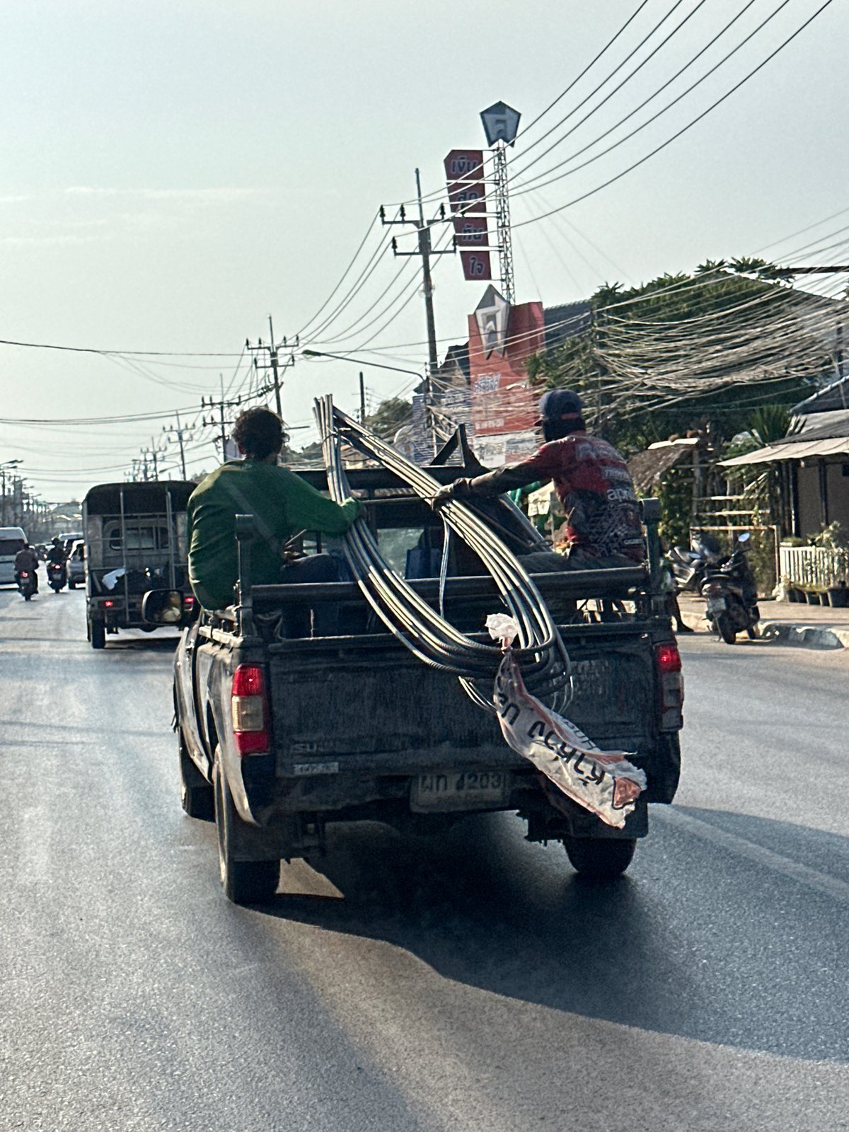 Two men handle materials from pickup truck in Thailand