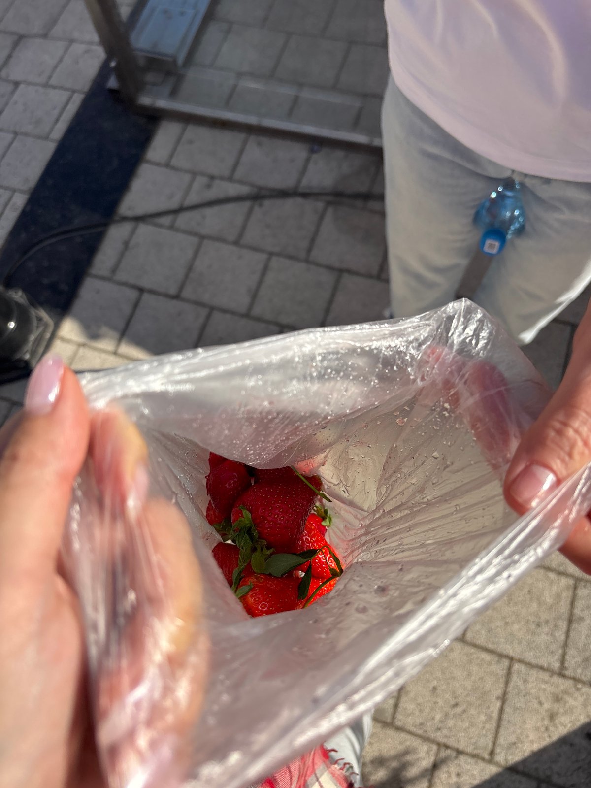 Woman buys strawberries on Krasnoyarsk sidewalk during morning outing