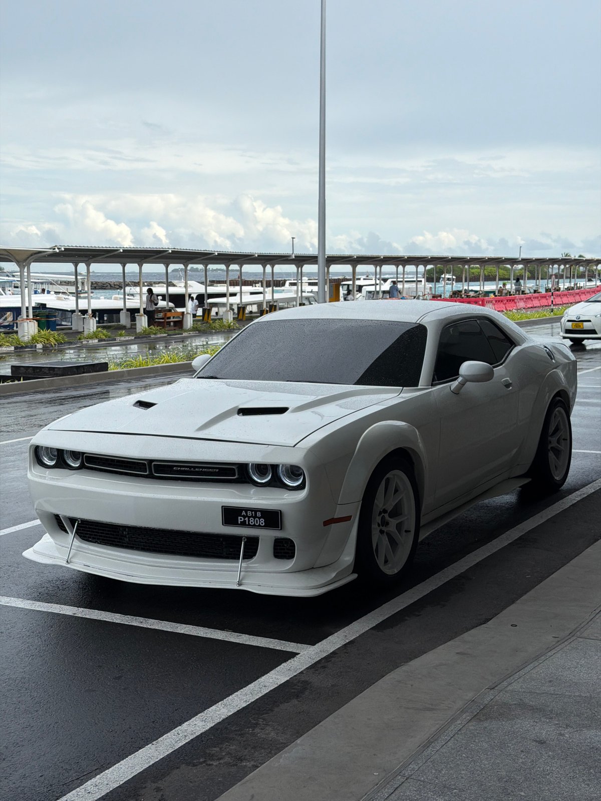 White Dodge Challenger spotted on wet pavement in Malé