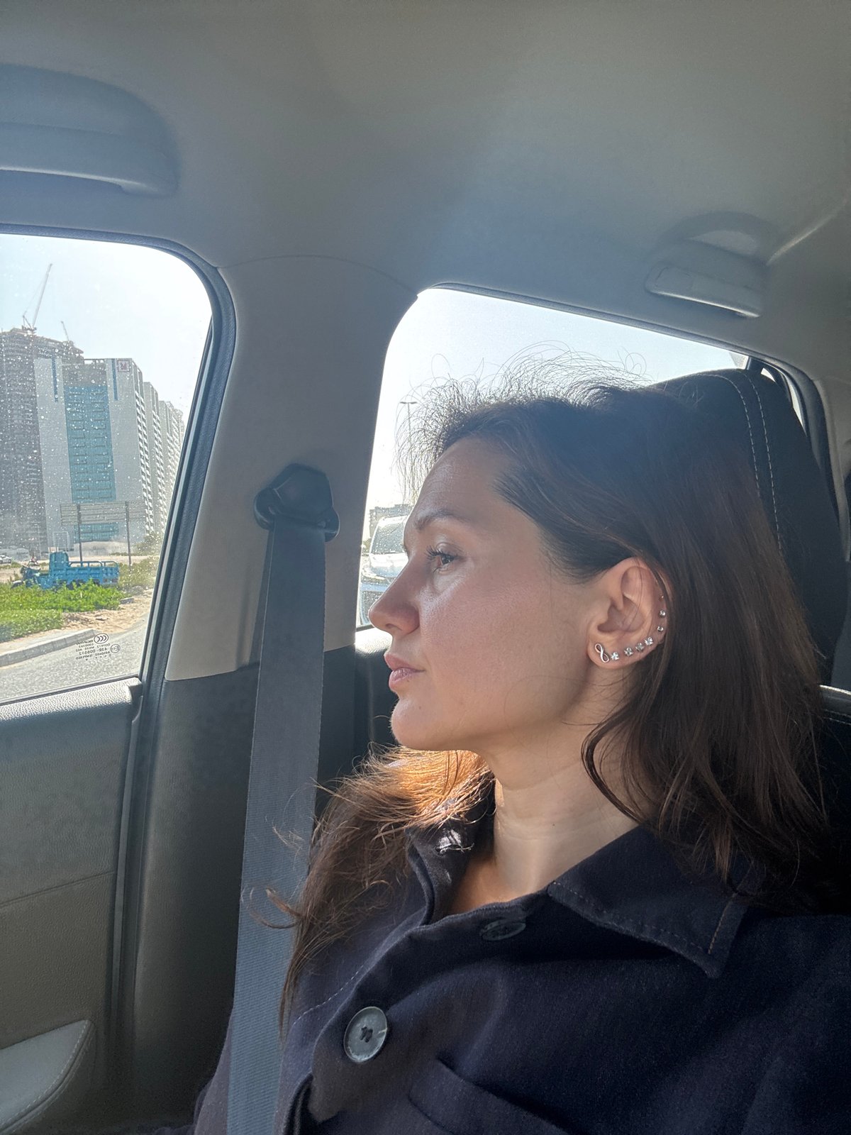 Woman in black jacket observed in car passenger seat, Dubai
