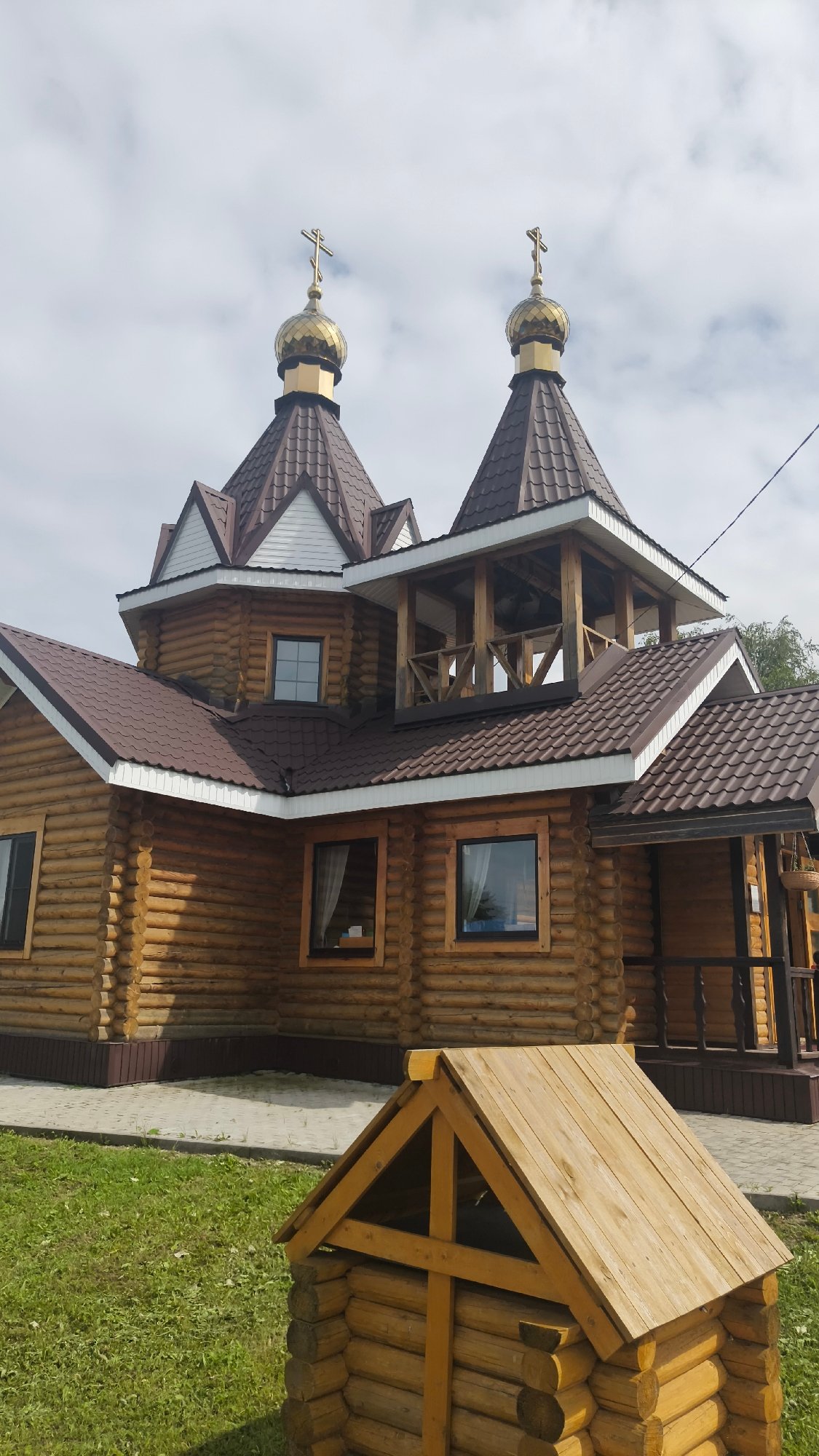 Log-built Orthodox church with golden domes in rural Russia