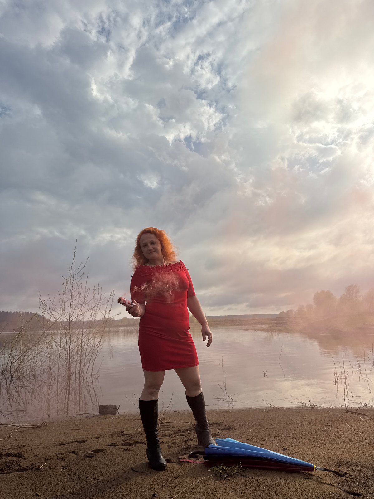 Woman conducts colorful smoke photo session near Russian lake