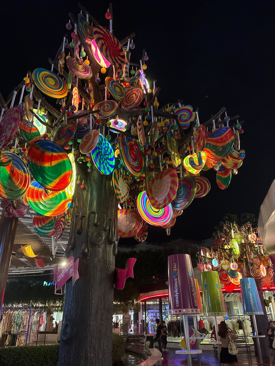 Candy store and illuminated tree sculpture documented in Kuta