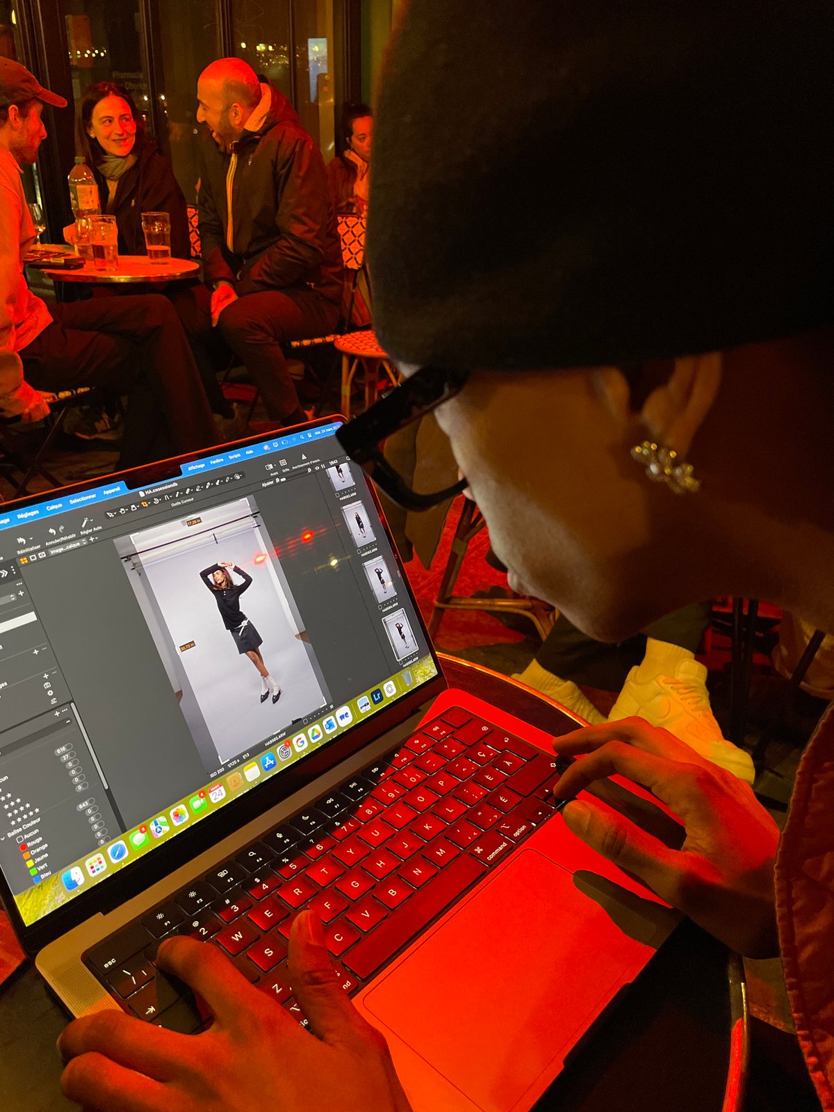 Person uses red-backlit MacBook laptop in Paris