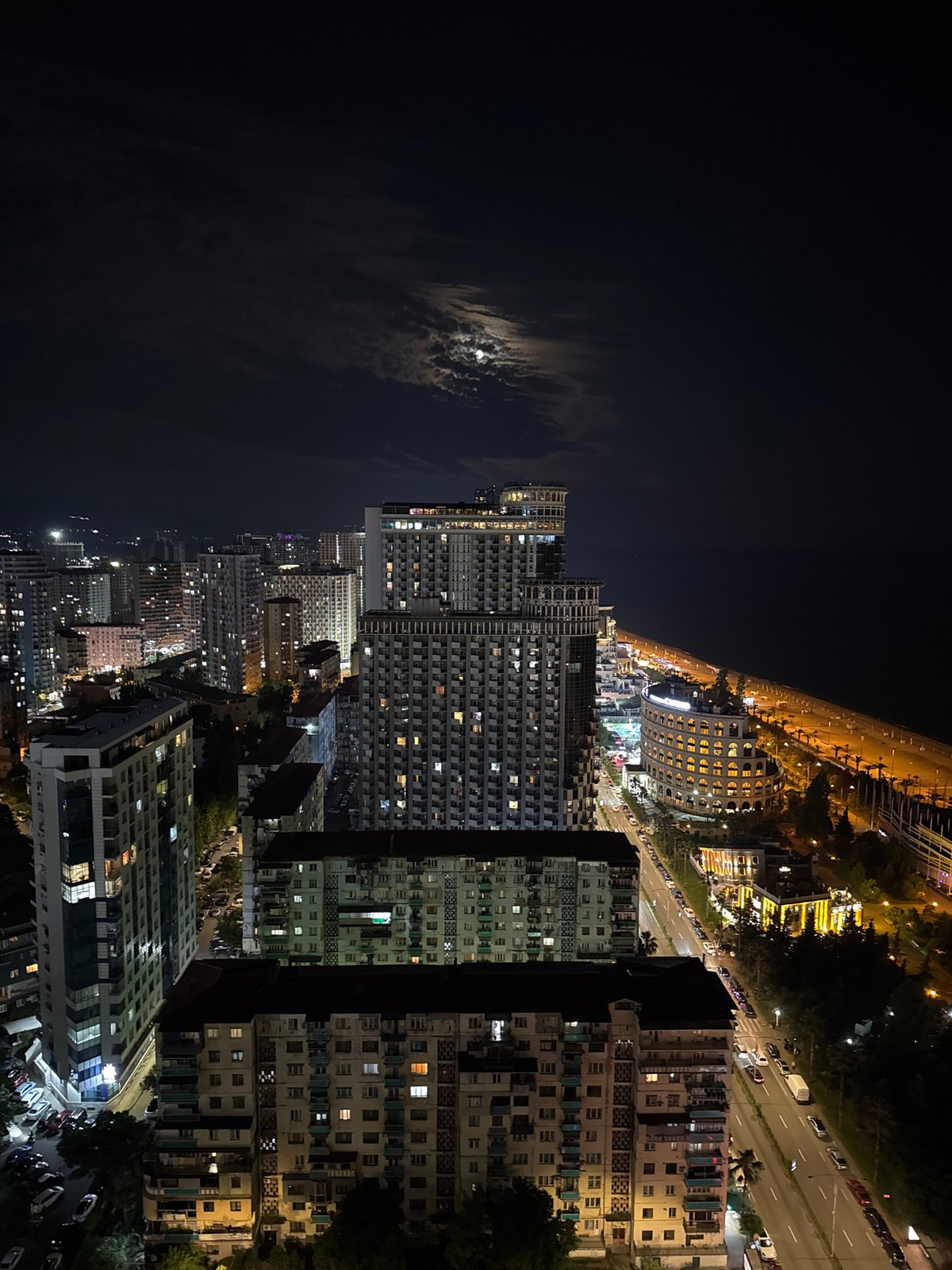 Batumi's nighttime skyline from above, coastal city lit up