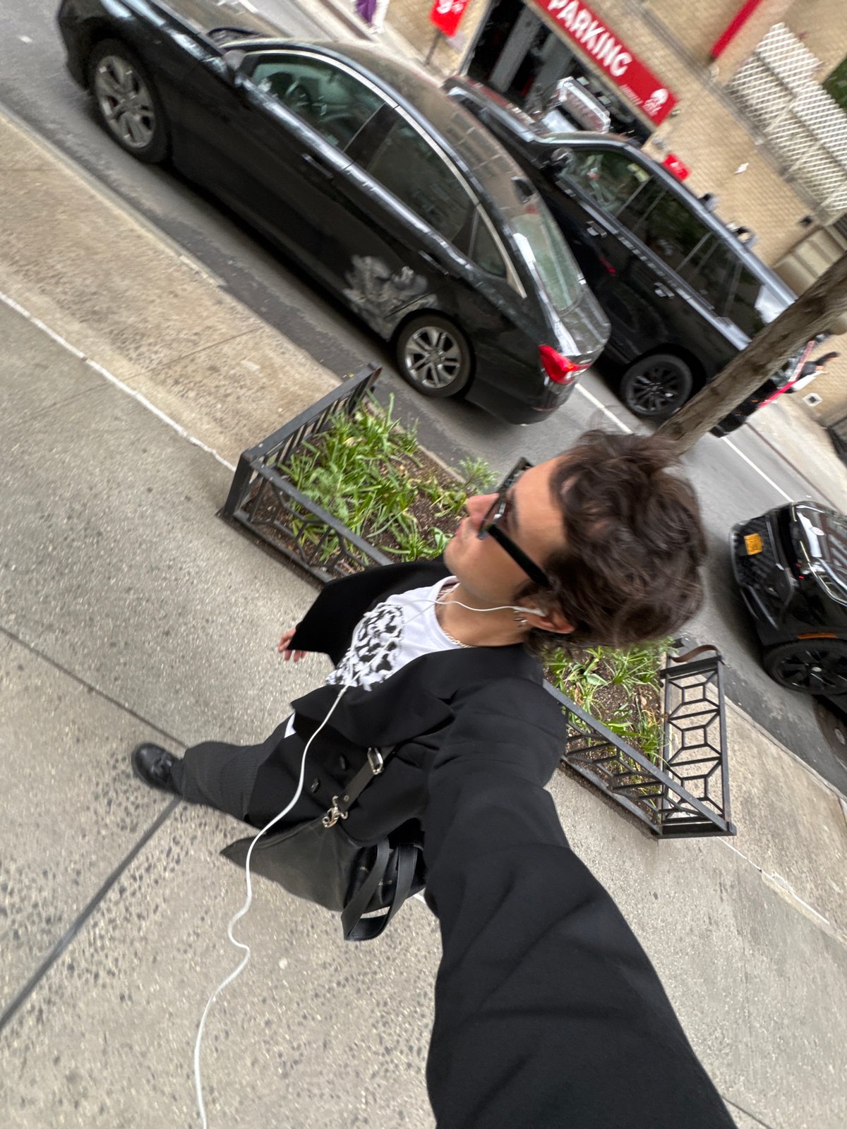 Person takes selfie on NYC sidewalk in business casual attire