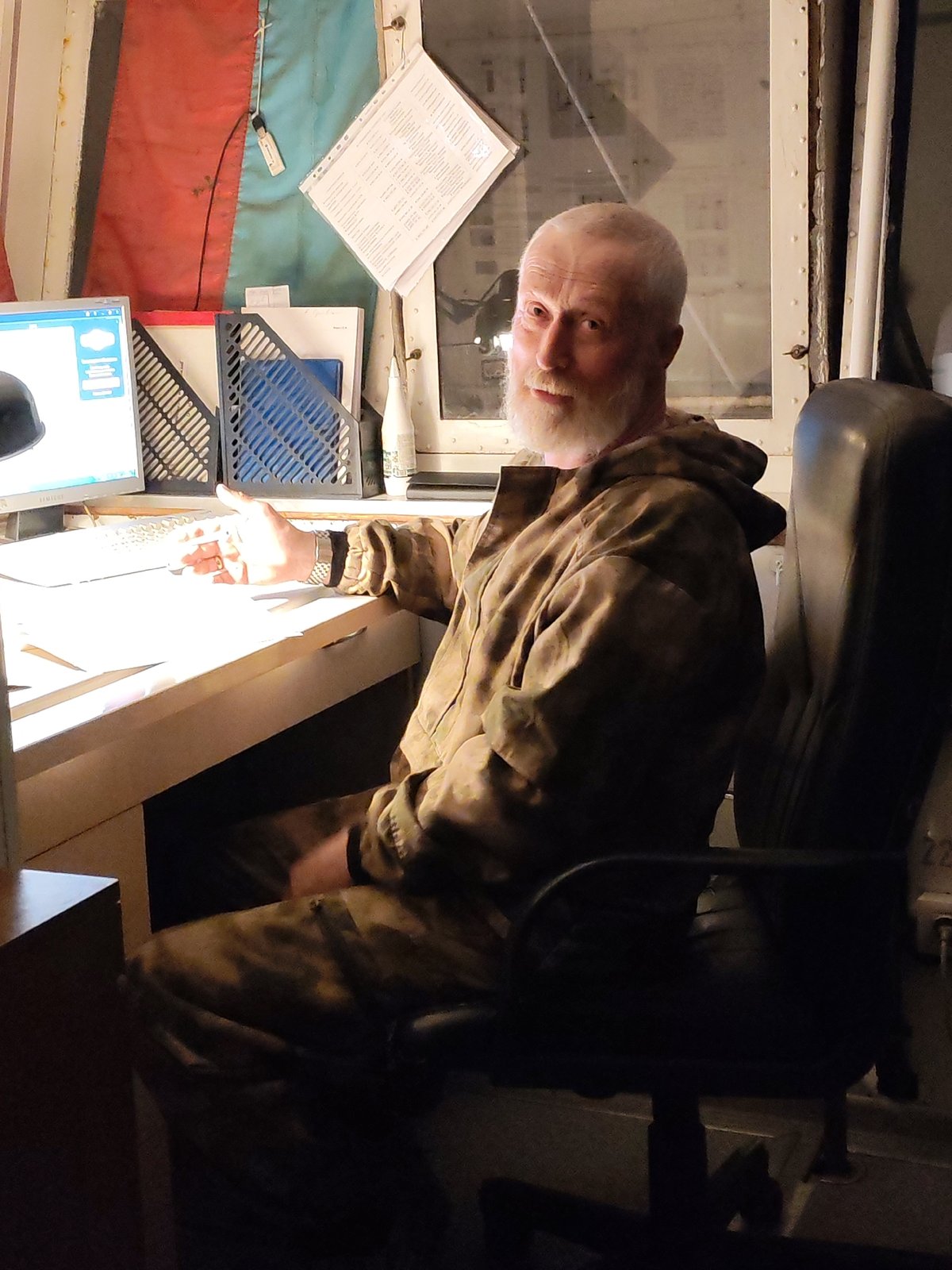 Man in camouflage observed at desk in Yakhroma office