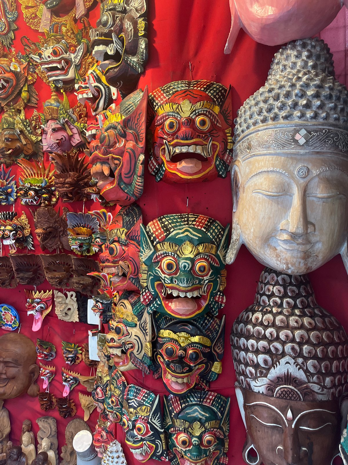 Traditional wooden masks displayed on fabric in Ubud, Indonesia