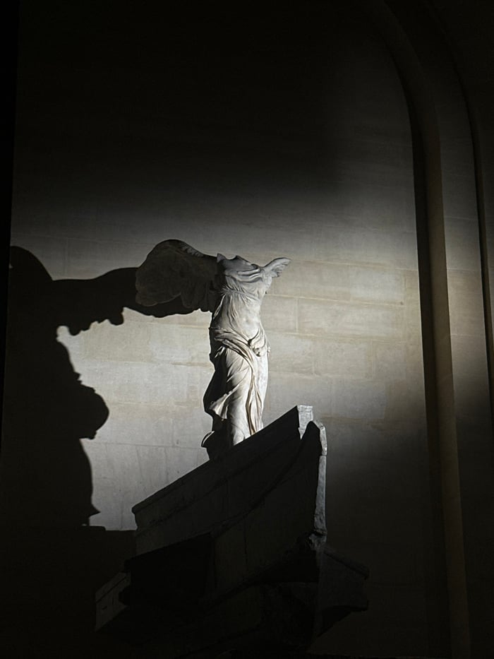 Evening visitors document iconic Louvre artworks and architecture