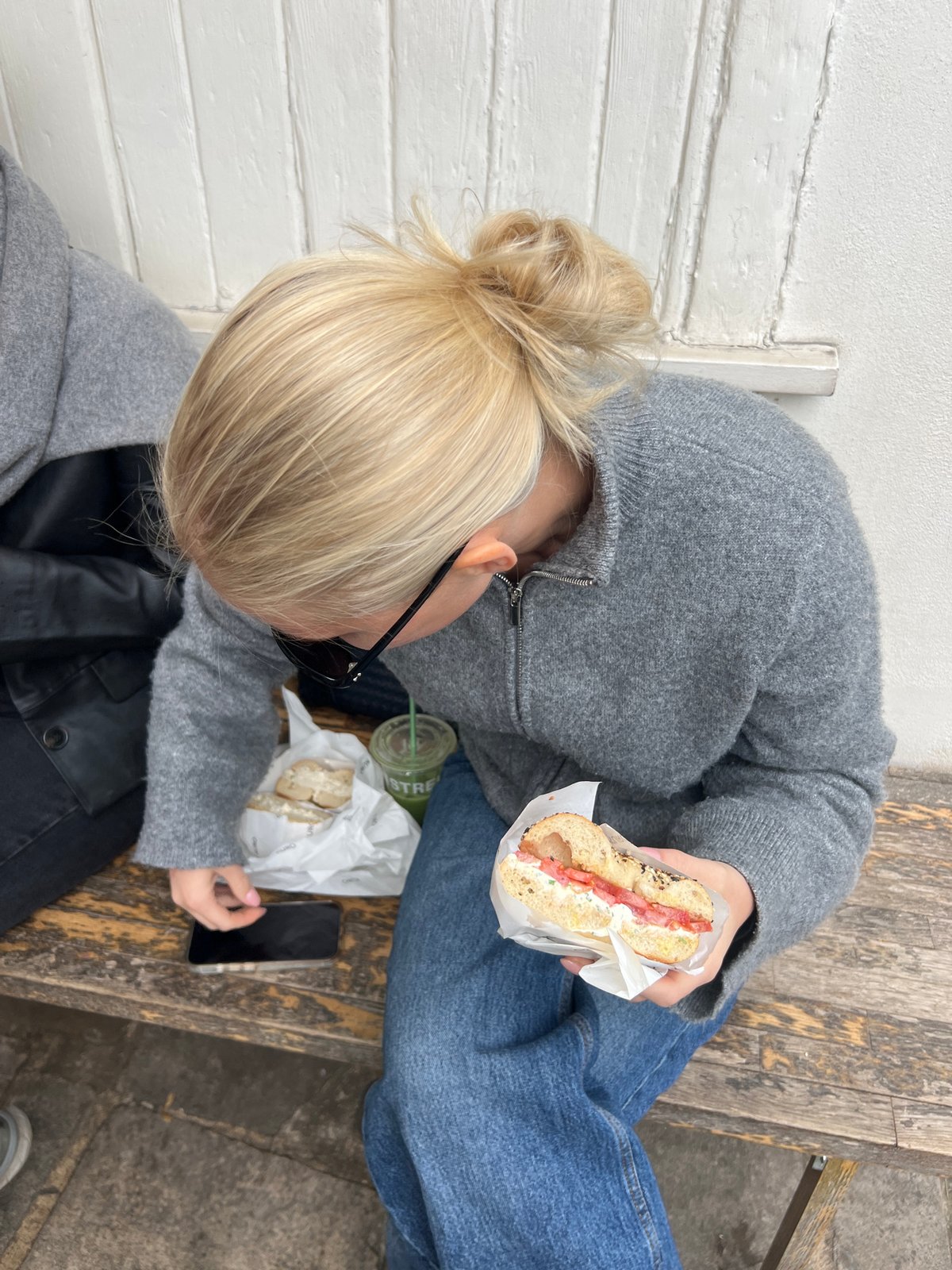 Young women enjoy bagel lunch outside London coffee shop