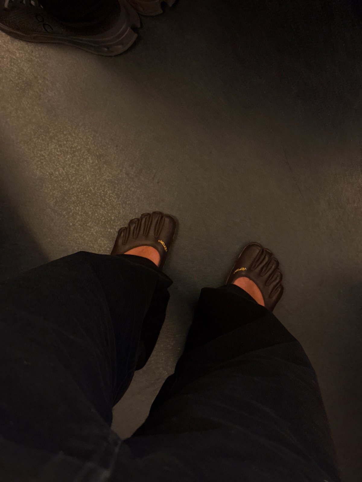Person takes mirror selfie in dimly lit Paris location