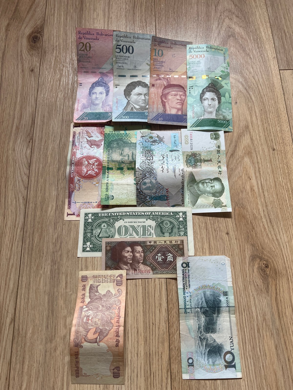 Foreign currency collection documented on wooden surface