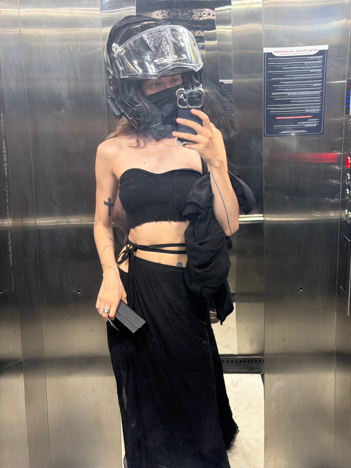 Helmeted person observed in elevator holding phone, Da Nang