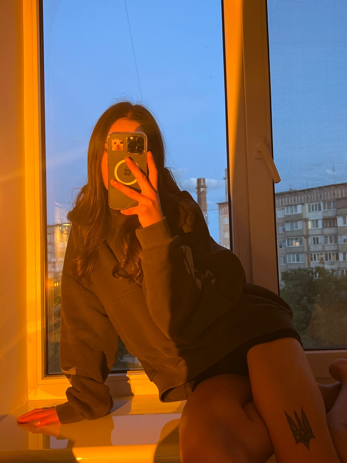 Woman takes evening selfies, reads with cat in Ternopil apartment