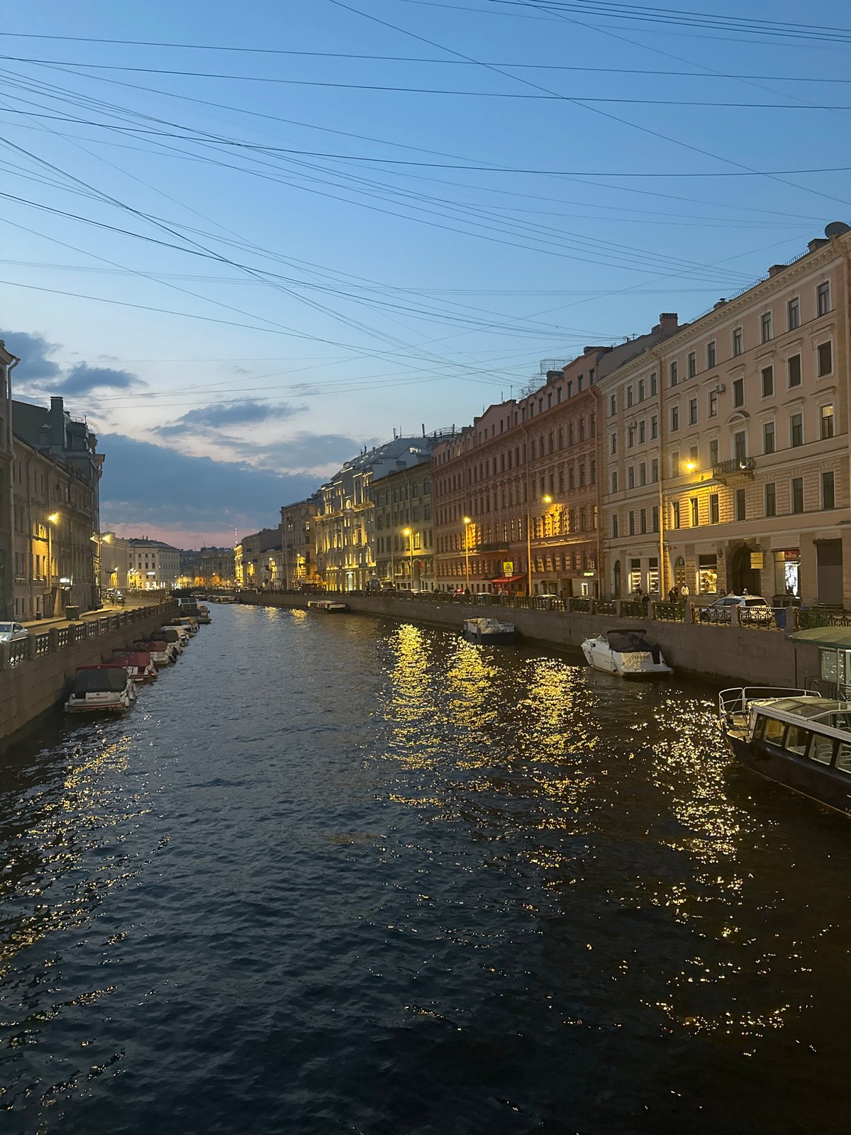 Urban canal scene documented at dusk, historical buildings illuminated