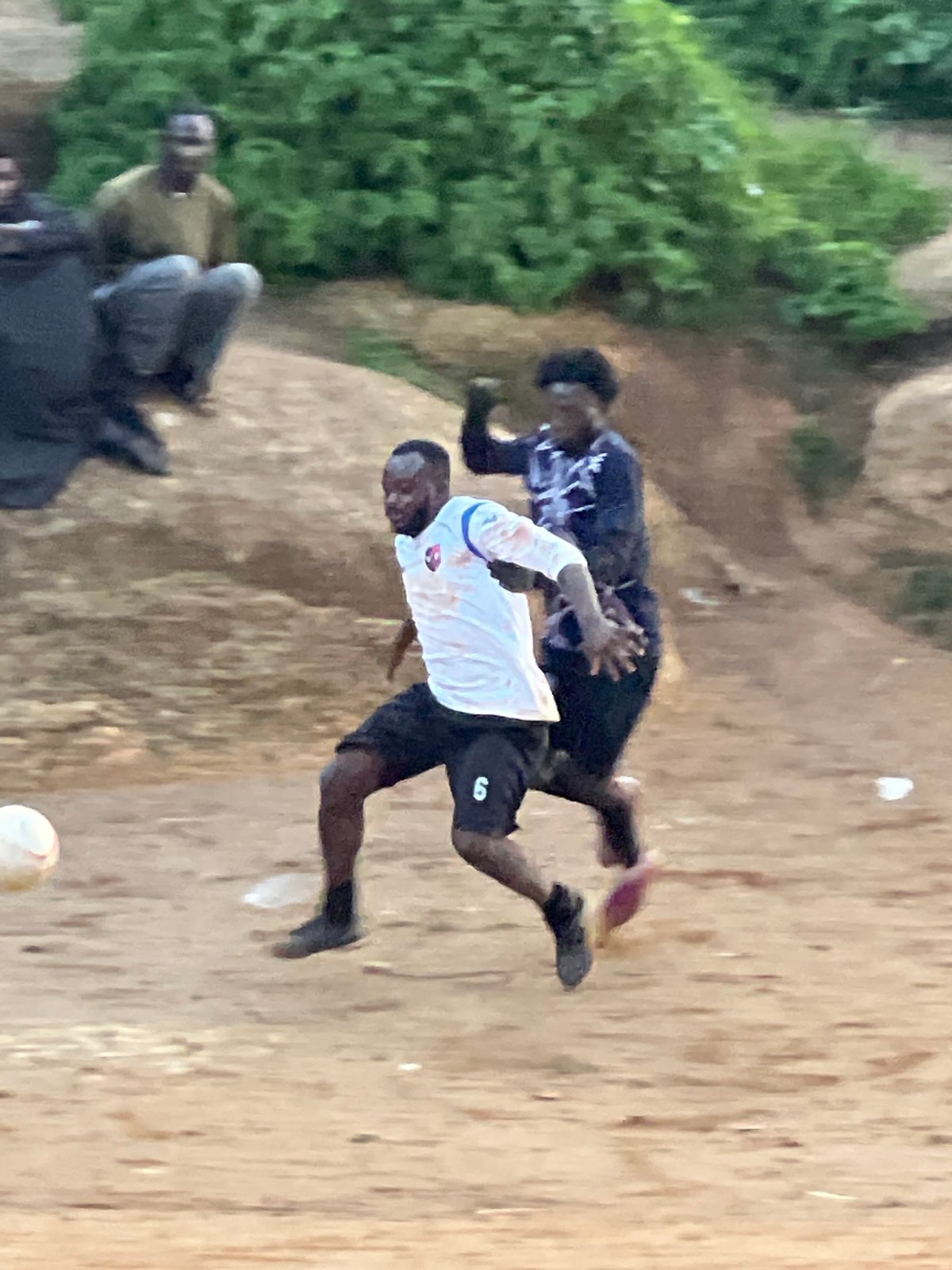 Pickup soccer match on a rocky dirt field in Jos, Nigeria